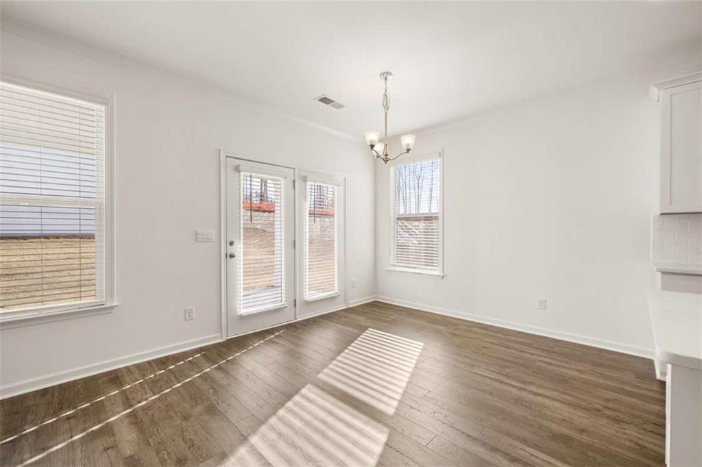1851 Lacebark Elm Way Lawrenceville, GA 30045 - Photo 22 of 63 a view of an empty room with wooden floor and a window
