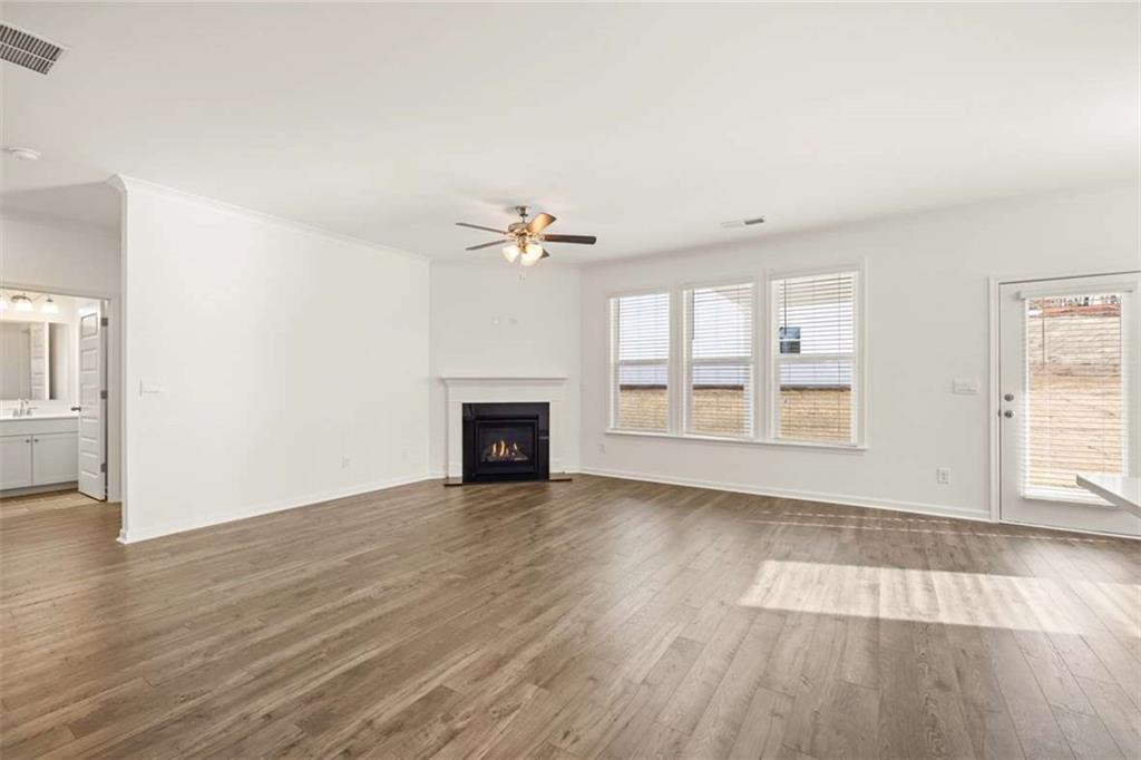 1851 Lacebark Elm Way Lawrenceville, GA 30045 - Photo 24 of 63 an empty room with wooden floor fireplace and windows