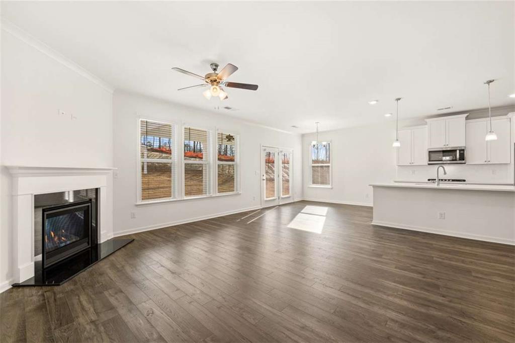 1851 Lacebark Elm Way Lawrenceville, GA 30045 - Photo 28 of 63 a view of an empty room with wooden floor and a kitchen