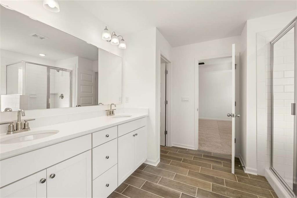 1851 Lacebark Elm Way Lawrenceville, GA 30045 - Photo 36 of 63 a spacious bathroom with a granite countertop sink a mirror and a shower