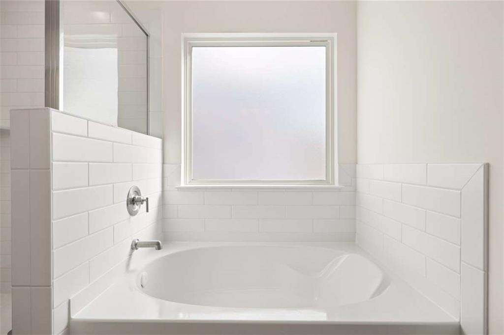 1851 Lacebark Elm Way Lawrenceville, GA 30045 - Photo 37 of 63 a white bath tub sitting next to a window