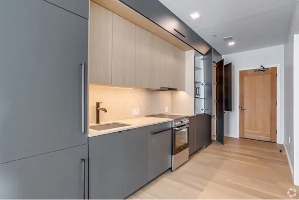 a kitchen with stainless steel appliances granite countertop a sink and a refrigerator
