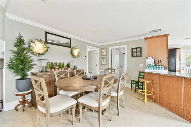 a large kitchen with kitchen island granite countertop a refrigerator a sink a stove a dining table and chairs