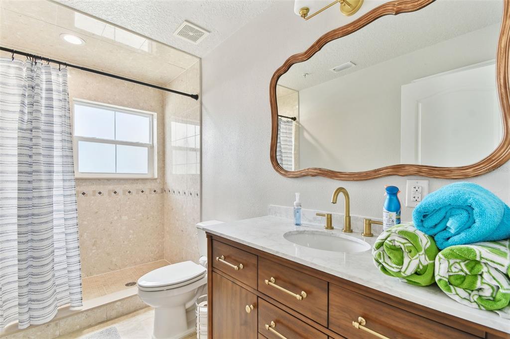16033 Gulf Boulevard Redington Beach, FL 33708 - Photo 27 of 98 a bathroom with a sink a toilet and a mirror