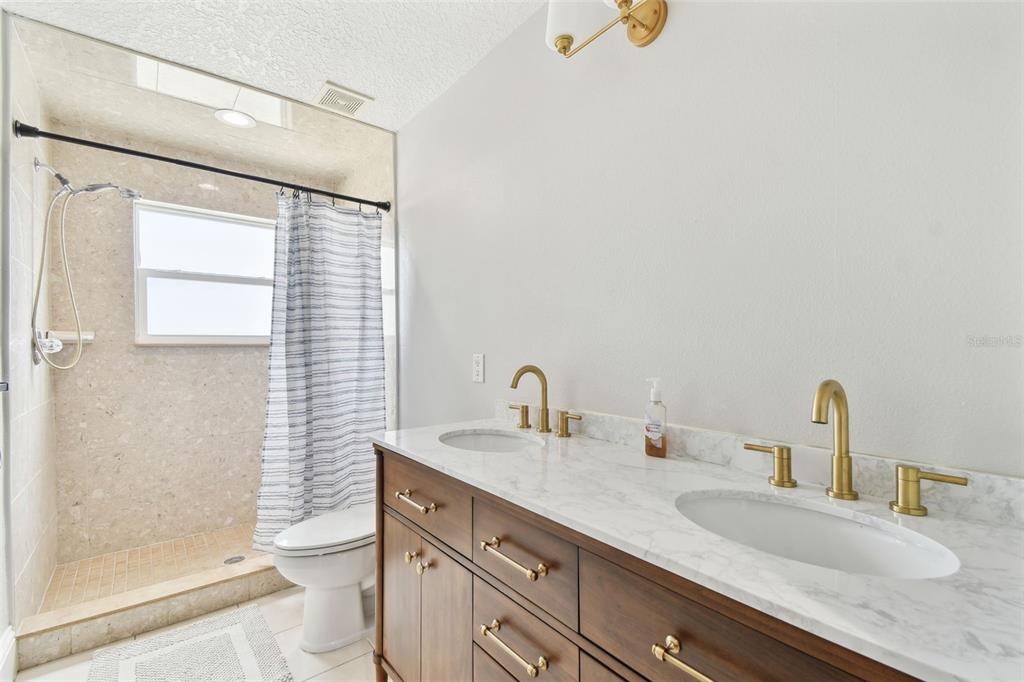 16033 Gulf Boulevard Redington Beach, FL 33708 - Photo 50 of 98 a bathroom with a granite countertop sink a toilet and shower
