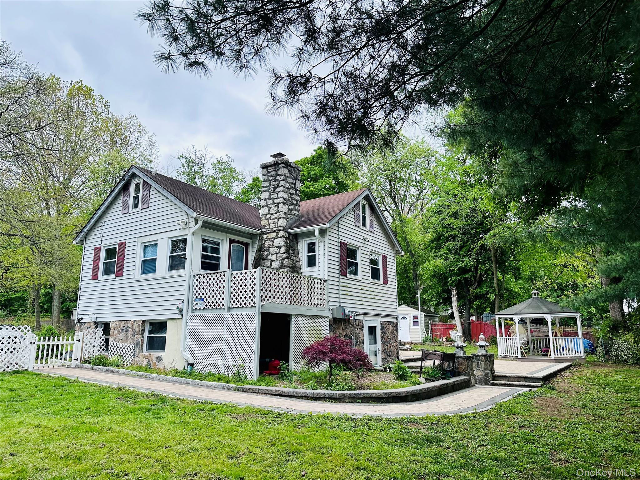 15 Pops Road Cortlandt Manor, NY 10567 - Photo 2 of 14 a front view of a house with a garden and trees