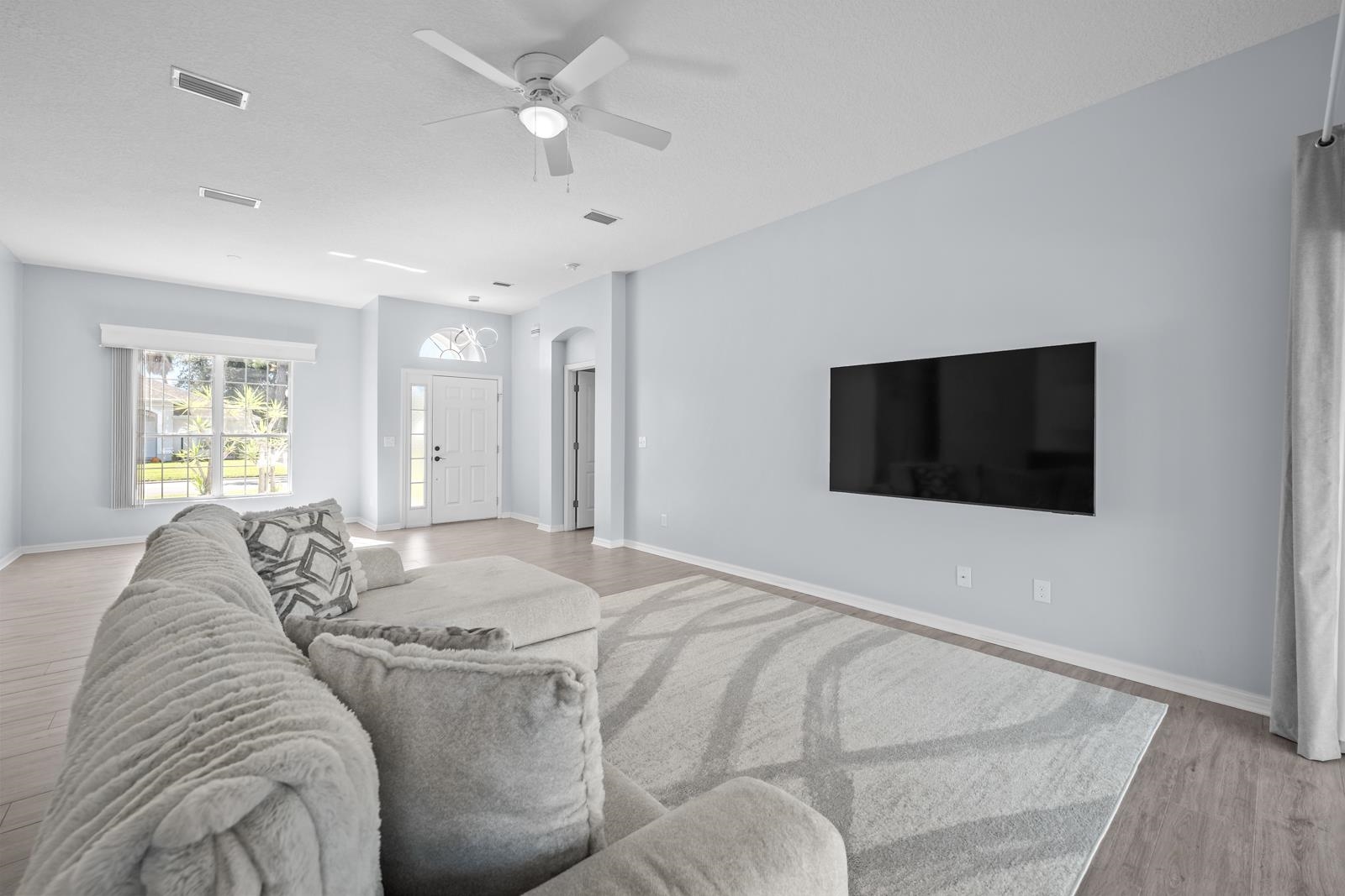 1116 Compass Row St. Augustine, FL 32080 - Photo 14 of 68 Living area with light wood finished floors, a ceiling fan, and arched walkways