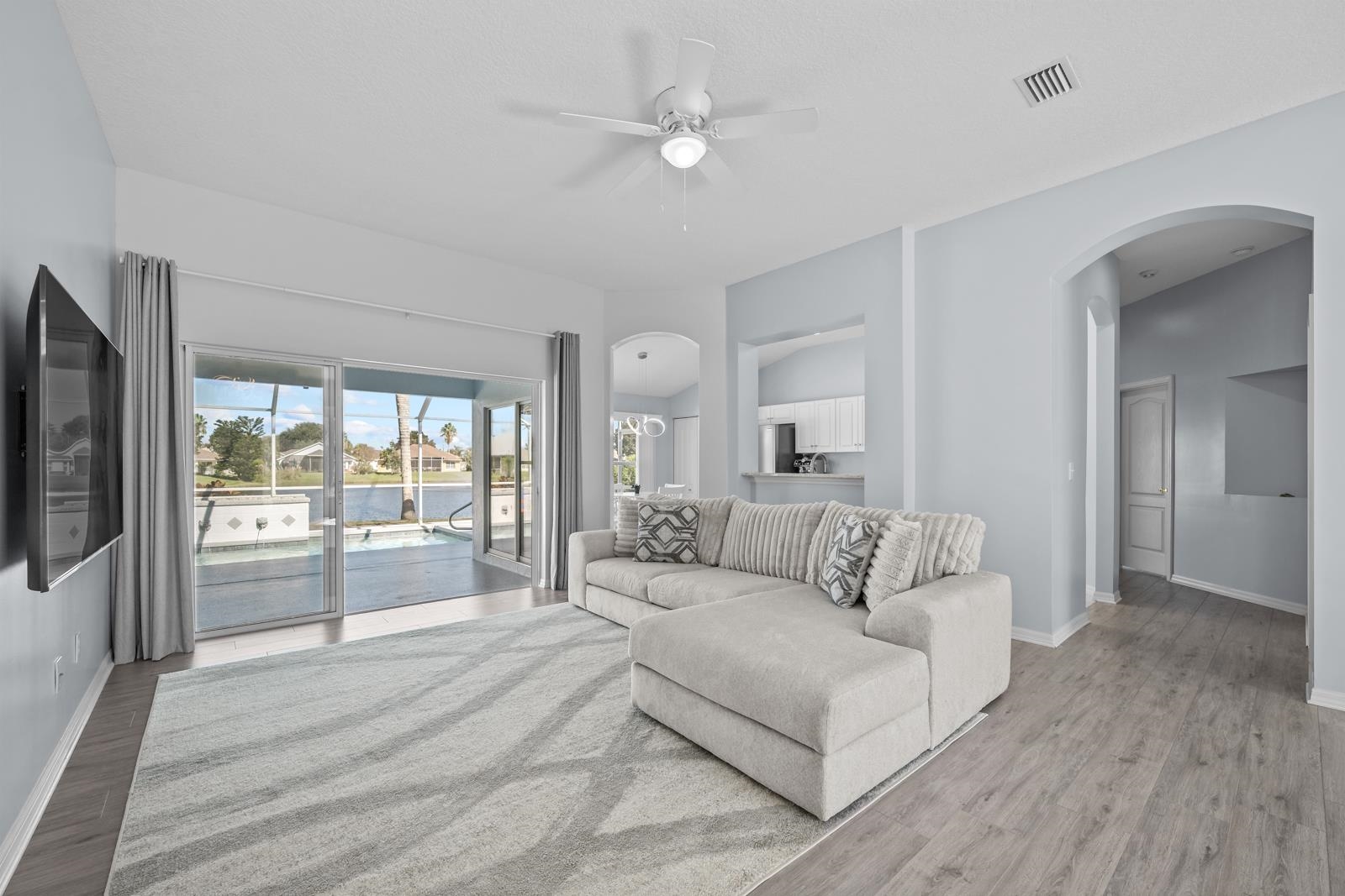 1116 Compass Row St. Augustine, FL 32080 - Photo 9 of 68 Living area featuring arched walkways, ceiling fan, and wood finished floors