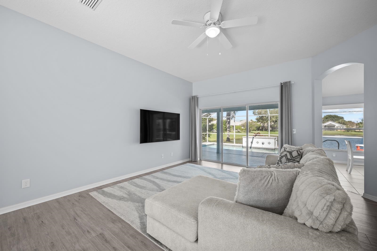 1116 Compass Row St. Augustine, FL 32080 - Photo 10 of 68 Living room featuring ceiling fan, wood finished floors, and arched walkways