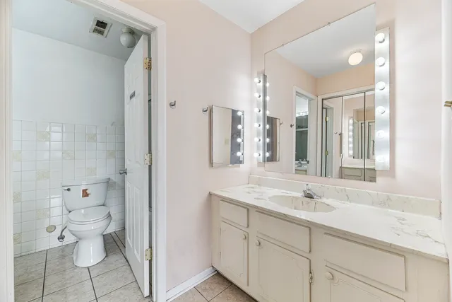 a bathroom with a granite countertop sink a toilet and a shower