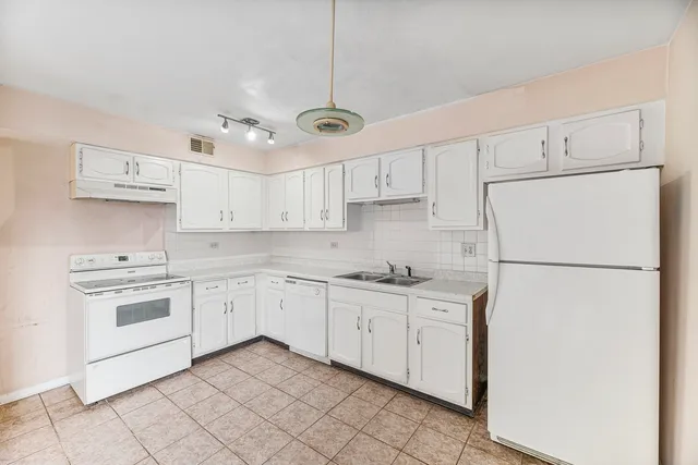 a kitchen with kitchen island white cabinets and white appliances