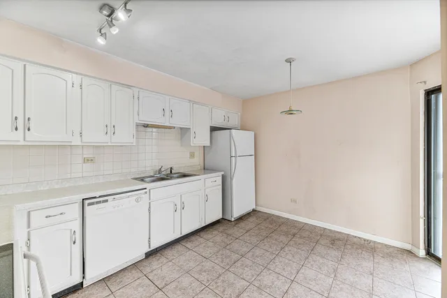 a kitchen with white cabinets and white appliances