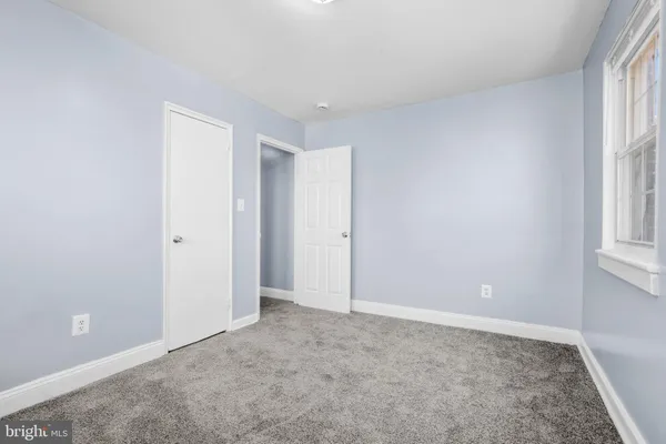 a bathroom with a sink mirror toilet and next to a window