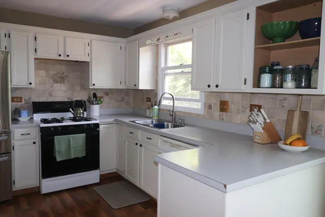 a kitchen with stainless steel appliances a stove a sink a refrigerator and cabinets