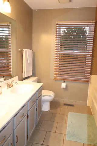 a bathroom with a granite countertop sink toilet and mirror