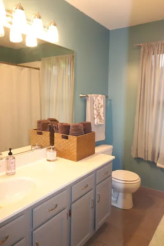a spacious bathroom with a double vanity sink toilet and a tub