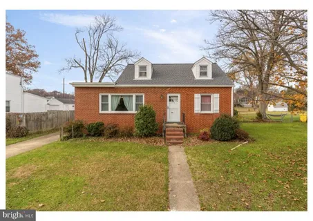 a view of a house with a big yard and large trees
