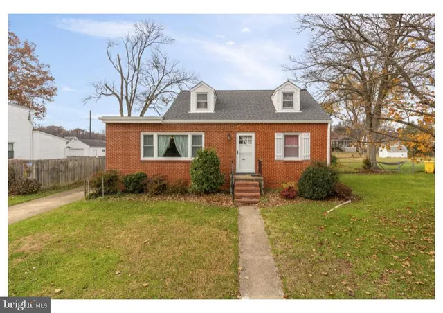 a view of a house with a big yard and large trees