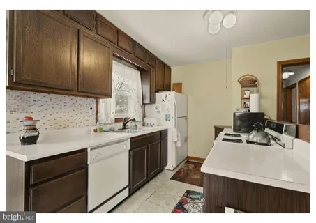 a kitchen with a sink a stove cabinets and a refrigerator