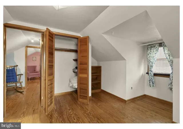 a view of empty room with wooden floor and cabinet
