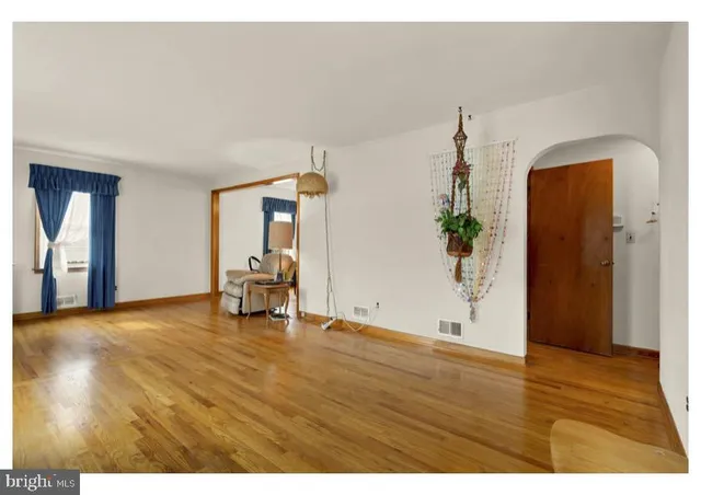 a view of empty room with wooden floor and furniture