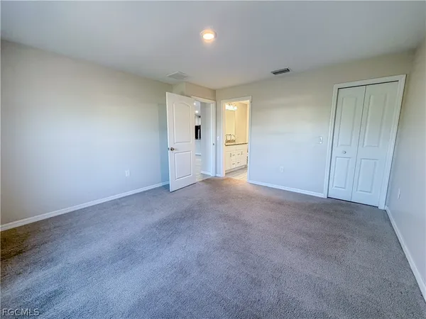 a view of an empty room and kitchen view