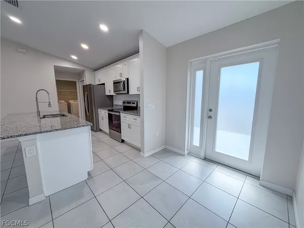 a kitchen with stainless steel appliances granite countertop a refrigerator sink and stove