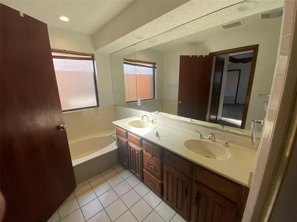 an empty room with windows and ceiling fan