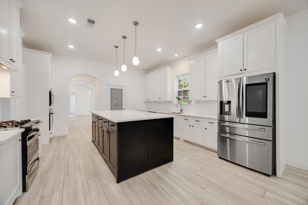 1016 Silver Creek Azle Road Azle, TX 76020 - Photo 14 of 40 Kitchen with appliances with stainless steel finishes, arched walkways, white cabinets, light countertops, and recessed lighting