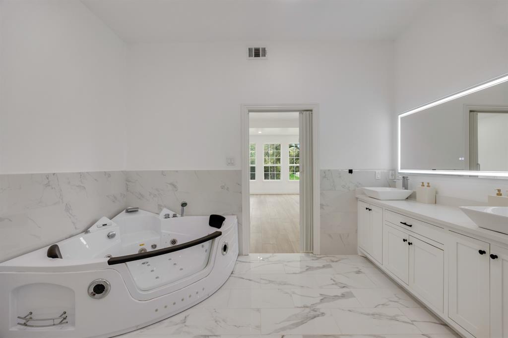 1016 Silver Creek Azle Road Azle, TX 76020 - Photo 29 of 40 Full bathroom with tile walls, double vanity, a tub with jets, wainscoting, and marble finish floors