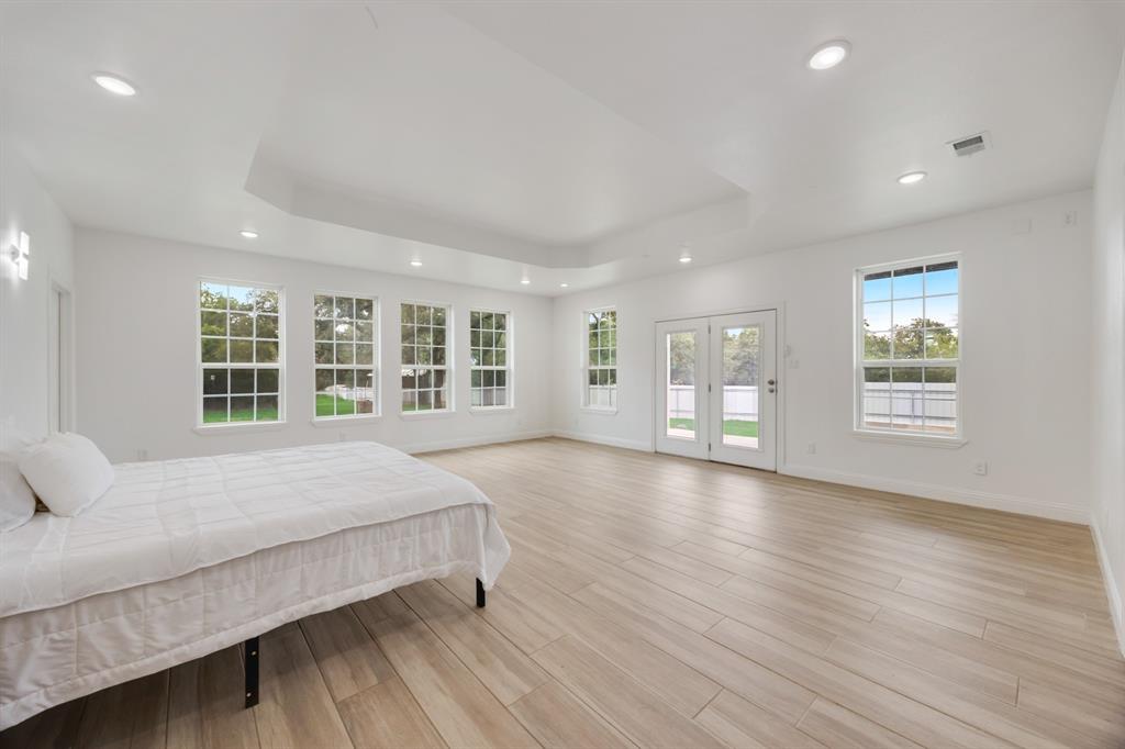 1016 Silver Creek Azle Road Azle, TX 76020 - Photo 30 of 40 Bedroom featuring access to outside, multiple windows, recessed lighting, a tray ceiling, and light wood-style flooring