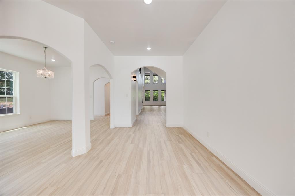 1016 Silver Creek Azle Road Azle, TX 76020 - Photo 34 of 40 Unfurnished room featuring recessed lighting, light wood-style floors, arched walkways, and a chandelier