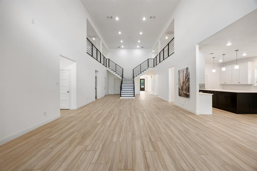 1016 Silver Creek Azle Road Azle, TX 76020 - Photo 6 of 40 Unfurnished living room featuring a high ceiling, arched walkways, light wood-style floors, recessed lighting, and stairs