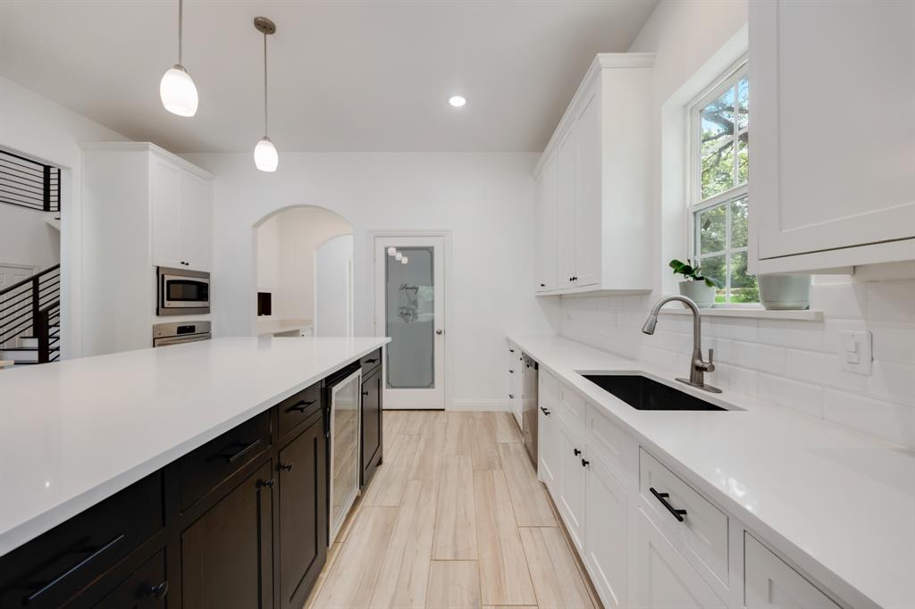 1016 Silver Creek Azle Road Azle, TX 76020 - Photo 9 of 40 Kitchen featuring white cabinets, backsplash, light countertops, pendant lighting, and wine cooler