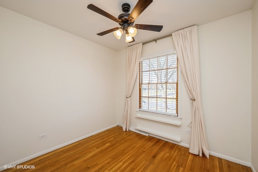 3208 Wren Lane Rolling Meadows, IL 60008 - Photo 12 of 18 an empty room with wooden floor fan and windows