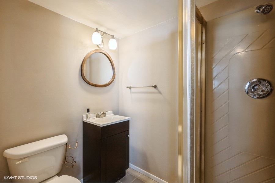 3208 Wren Lane Rolling Meadows, IL 60008 - Photo 13 of 18 a bathroom with a toilet sink vanity and mirror
