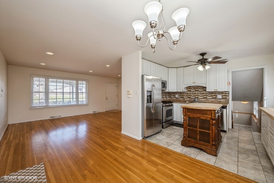 3208 Wren Lane Rolling Meadows, IL 60008 - Photo 5 of 18 a kitchen with stainless steel appliances kitchen island granite countertop a stove a refrigerator and a wooden floor
