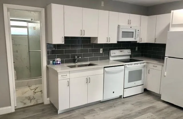 a kitchen with white cabinets and white appliances