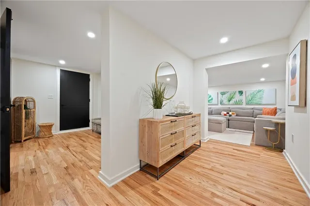 a large room with stainless steel appliances kitchen island white cabinets and wooden floor