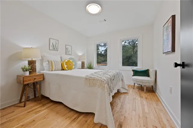 a spacious bedroom with a bed and wooden floor