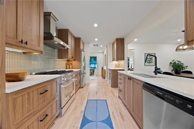 a large kitchen with stainless steel appliances lots of counter space and a sink