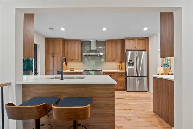 a kitchen with stainless steel appliances granite countertop a refrigerator and a stove top oven