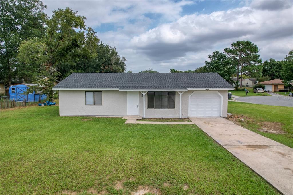 9347 Spring Road Ocala, FL 34472 - Photo 1 of 1 a front view of a house with a yard and garage
