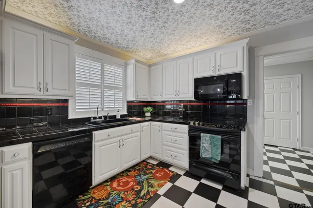 a kitchen with stainless steel appliances a sink stove and cabinets
