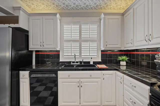 a kitchen with stainless steel appliances granite countertop a sink a stove and a refrigerator