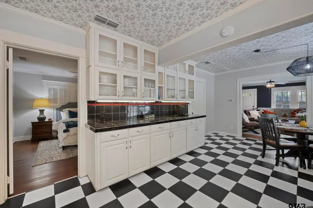 a kitchen with a checkered floor and white cabinets