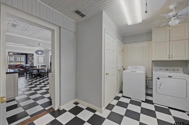 a kitchen with a checkered floor and white cabinets