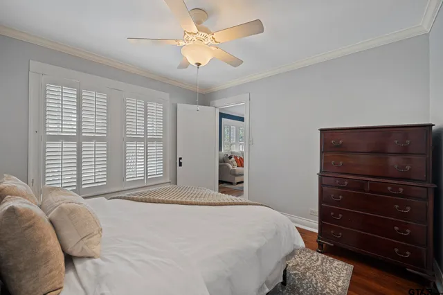 a bedroom with a bed a dresser and a window