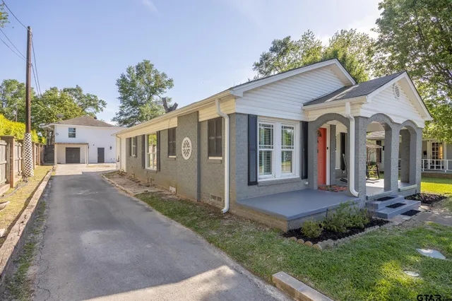 a front view of a house with a yard and potted plants