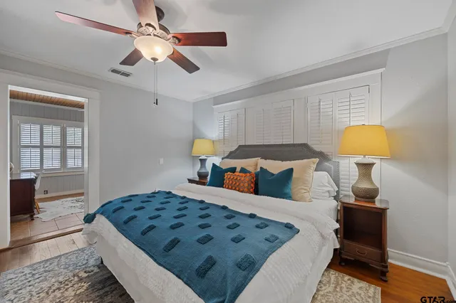 a bedroom with a bed lamps and a dresser